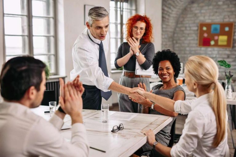 two-happy-business-people-shaking-hands-meeting-while-other-colleagues-are-applauding-them-office-fotor-20230915151056